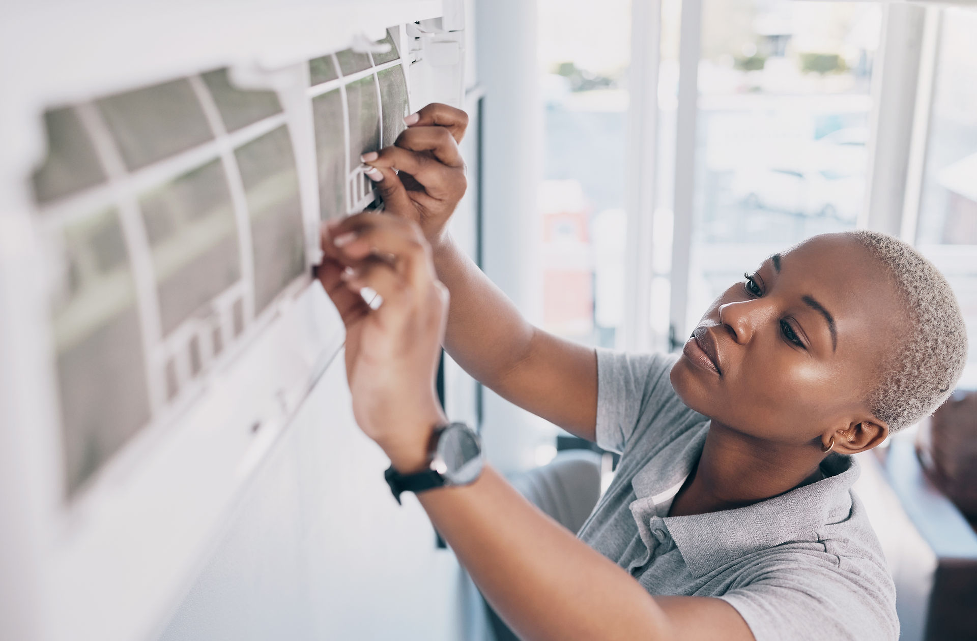 Woman checking air conditioner filter
