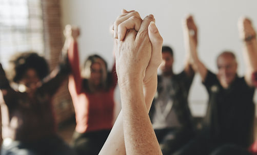 A diverse group of individuals holding hands, symbolizing unity and teamwork.