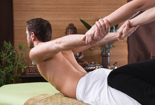 An image of a client during a body massage having body stretched
