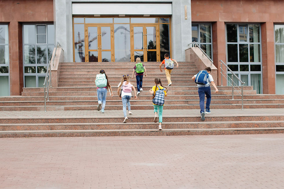 Happy, mentally healthy kids running up steps to school