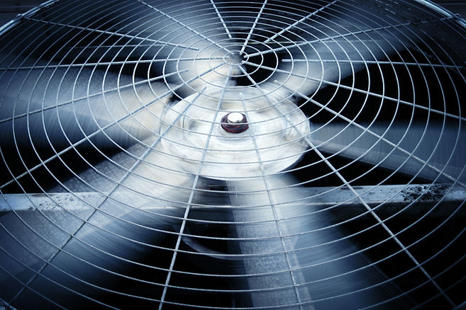 Large fan of heating/cooling system. Fan blades are motion blurred, grill is sharp
