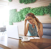 Woman listening to her phone at a coffee shop