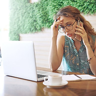 Woman listening to her phone at a coffee shop