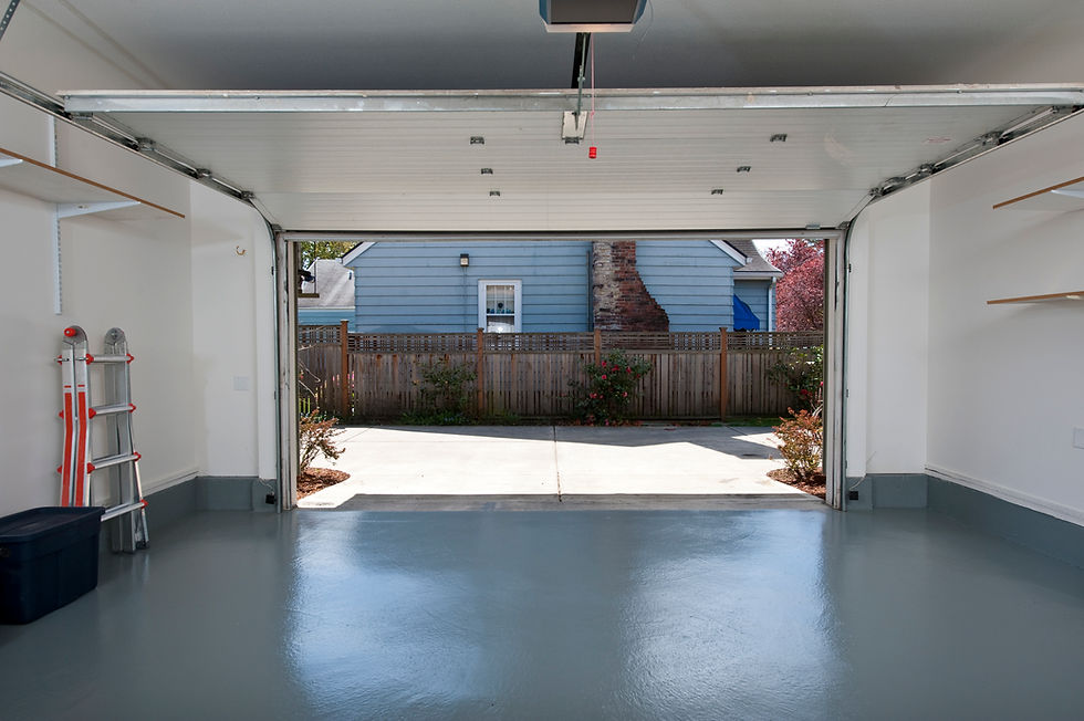 Clean, empty home garage with a glossy grey epoxy floor and an open automatic door