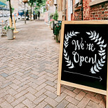 Chalk A-board sign that says we're open, main image for the retail and restaurants section