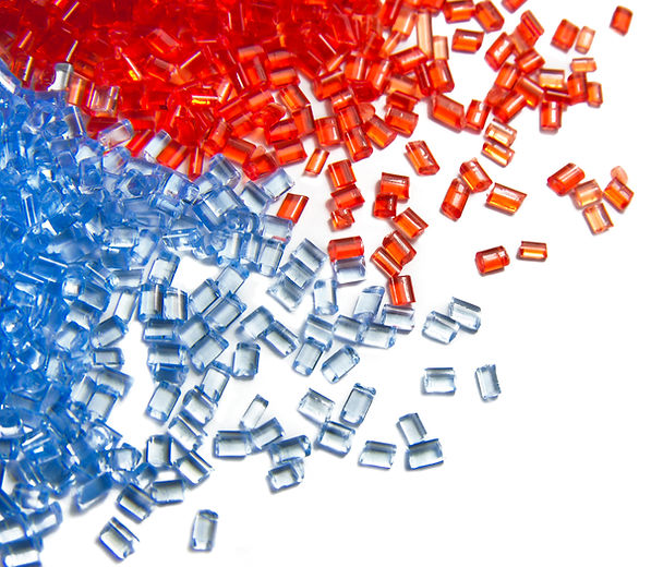 Blue and red plastic granules scattered across a white background