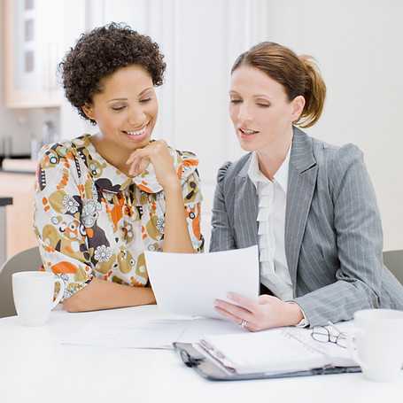 two women looking at the document