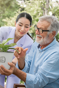 in-home caregiver with senior taking care of plants