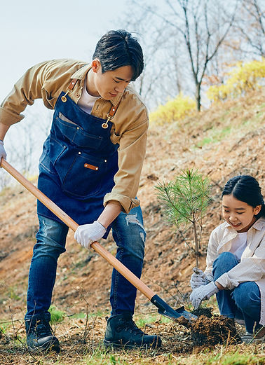 Père et fille plantant un arbre