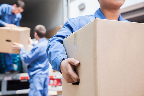 Movers unloading a moving van filled with boxes