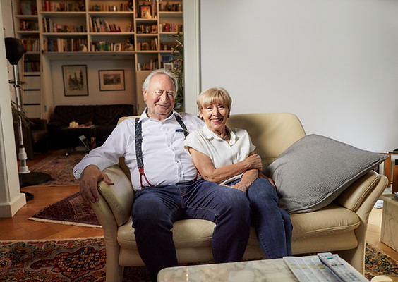Ehepaar dessen Haus verkauft wurde sitzen auf dem Sofa