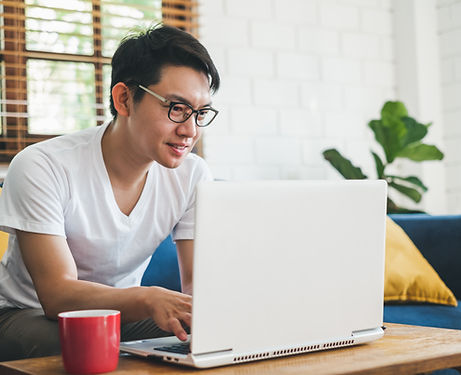 A man looking at a computer screen and smile