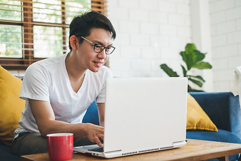 A man looking at a computer screen and smile
