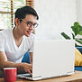 A man looking at a computer screen and smile