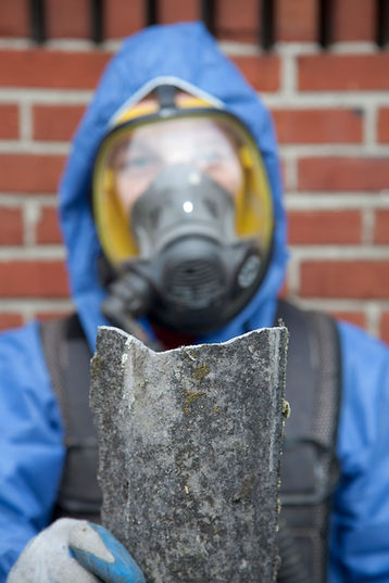 A worker with a mask inspecting a concrete piece