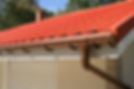 Close-up of a red-tiled roof with a brown gutter system
