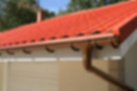 Red tile roof with a brown gutter system