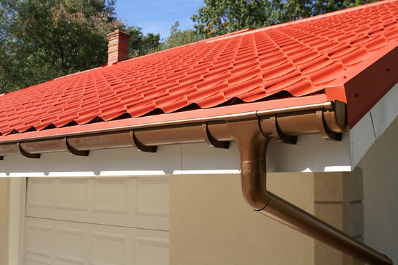 Modern copper guttering fixed below a clean red tiled roof