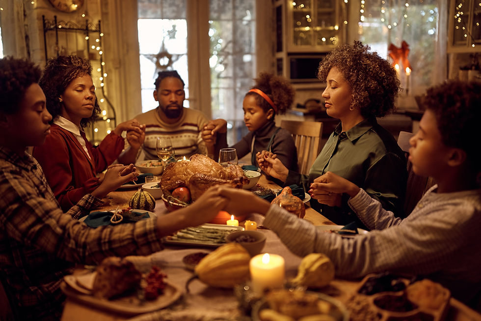 Family Holding Hands to say Grace aroundDinner Table
