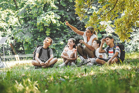 Group if happy people sitting in the grass.