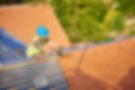 a roofer nails on the roof tiles