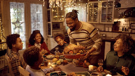 An individual holding a turkey at a family holiday