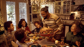 An individual holding a turkey at a family holiday