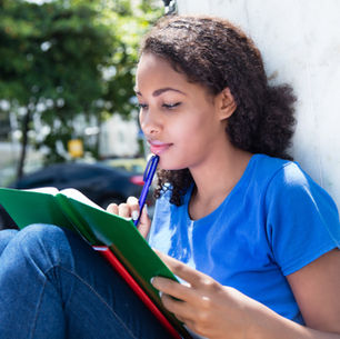 A young girl deeply immersed in writing her story, pen in hand and imagination soaring.