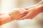 Adult female's hands holding an elderly person's hand