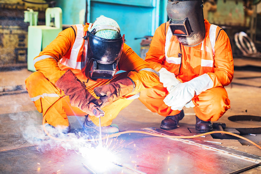 Welders working in industrial setting