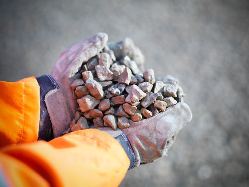 Gloved hands holding crushed stones