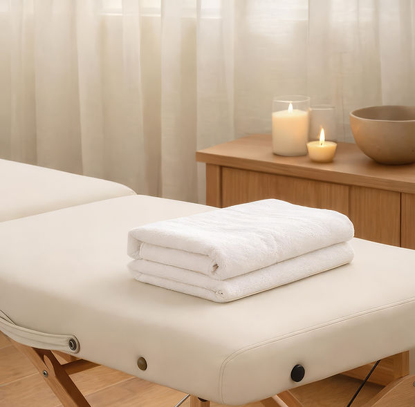 Calm massage therapy treatment room with massage table, fresh towels, and candles
