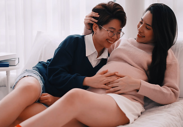 A woman touching the womb of another pregnant woman