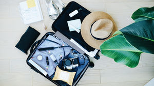 An open suitcase being packed for a vacation