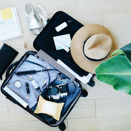 Open suitcase with clothes and travel essentials