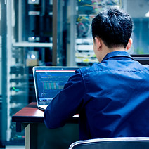 Männlicher Mitarbeiter sucht Daten in einem Laptop-PC