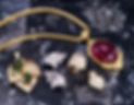 Ring, earrings, brooch, and necklace with jewels on marble surface, high angle view