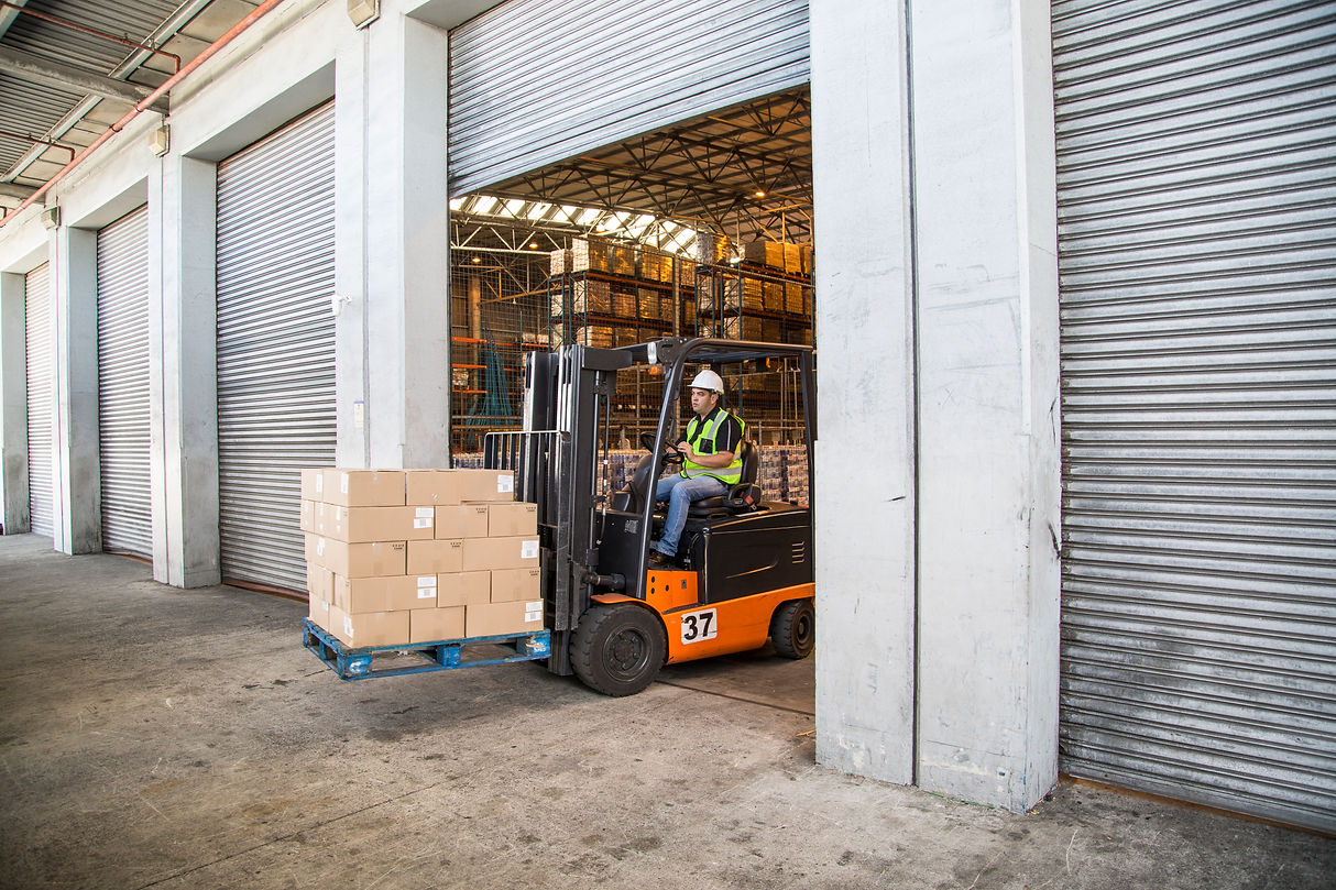 worker operating forklift to move boxes in warehouse