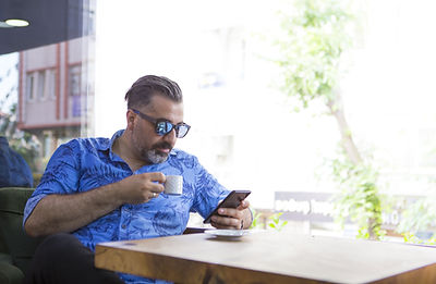 Person using mobile phone in café