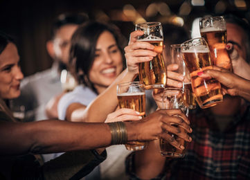 Multiple people gathering laughing, having drinks cheers
