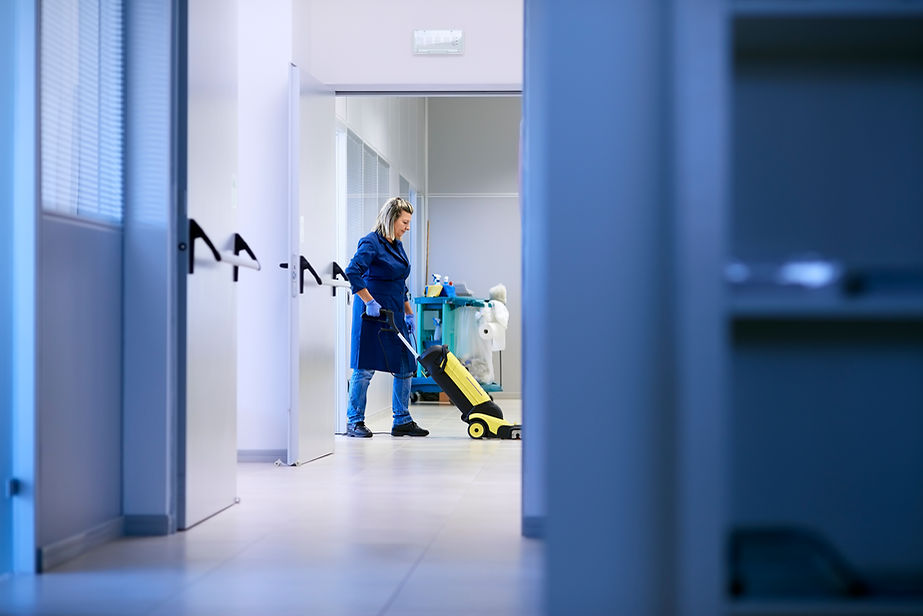 Woman professional maid cleaning and washing floor with machinery