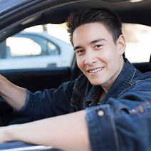 Young Driver sitting in a car smiling