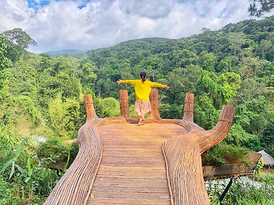 Young Asian woman standing on a large hand with a mountain view in Da Lat, Vietnam