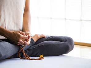 sitting in lotus pose with prayer beads