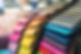 A colorful stack of fabric swatches in pink, orange, yellow, blue, and gray hues.