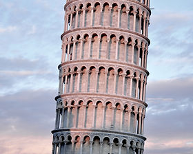 Leaning Tower of Pisa at sunset with soft pink light.