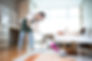Woman cleaning floor with vacuum cleaner in living room
