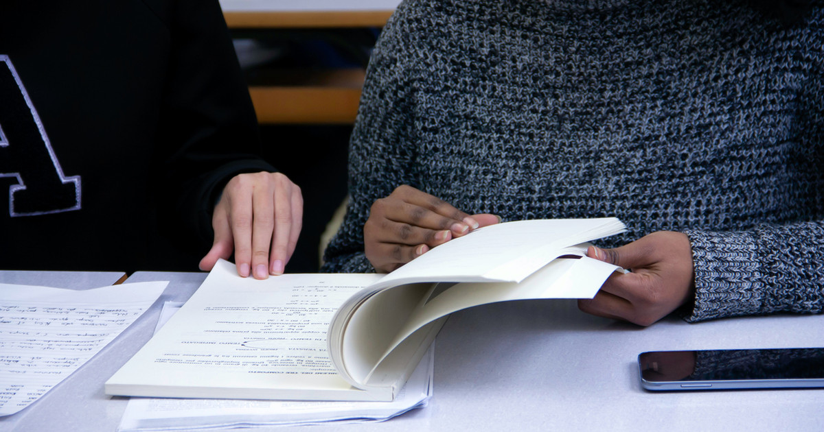 A patient reviewing notes and questions before meeting with a pain specialist during an outpatient consultation.