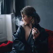 煙を吐き出す女性