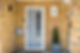 A general view of an entrance with a grey front door, mail box and Topiary Spiral plant in